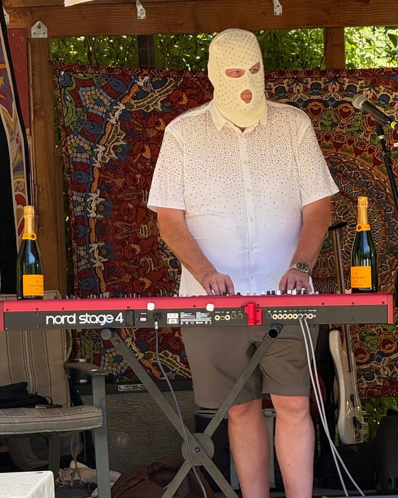Surveillance image of the subject as CHAMPAGNE HEIST KEYBOARDIST, the ivory tickler.
